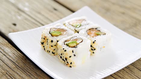 Uramaki-sushi-served-on-plate-against-wooden-background