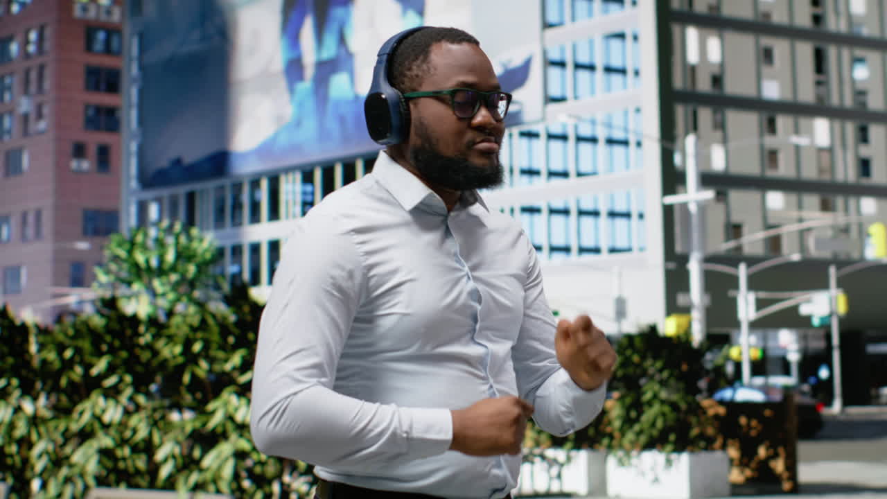 African american man dancing and listening to music on the street