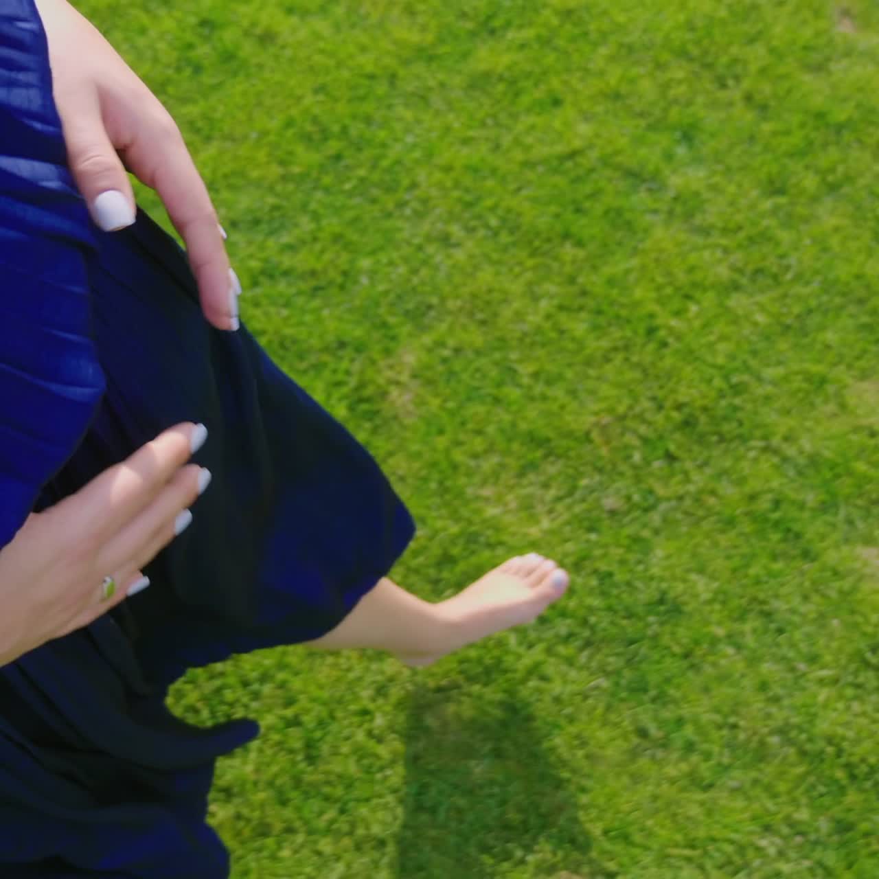 임산부가 맨발로 풀밭을 걷고 있다