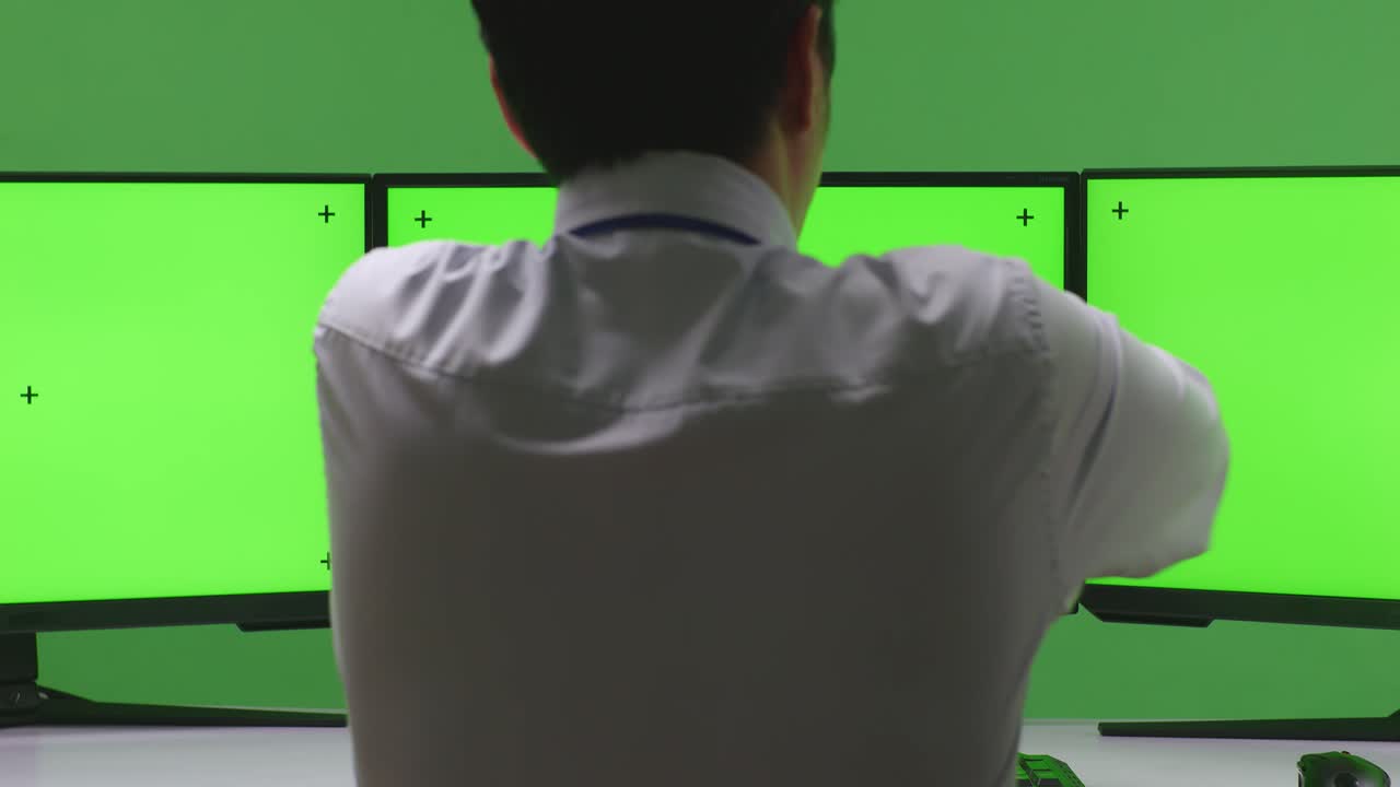 hombre de negocios comprobando el reloj en múltiples monitores