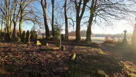 fpv flying around headstones in snowy sunrise churchyard cemetery during winter golden hour