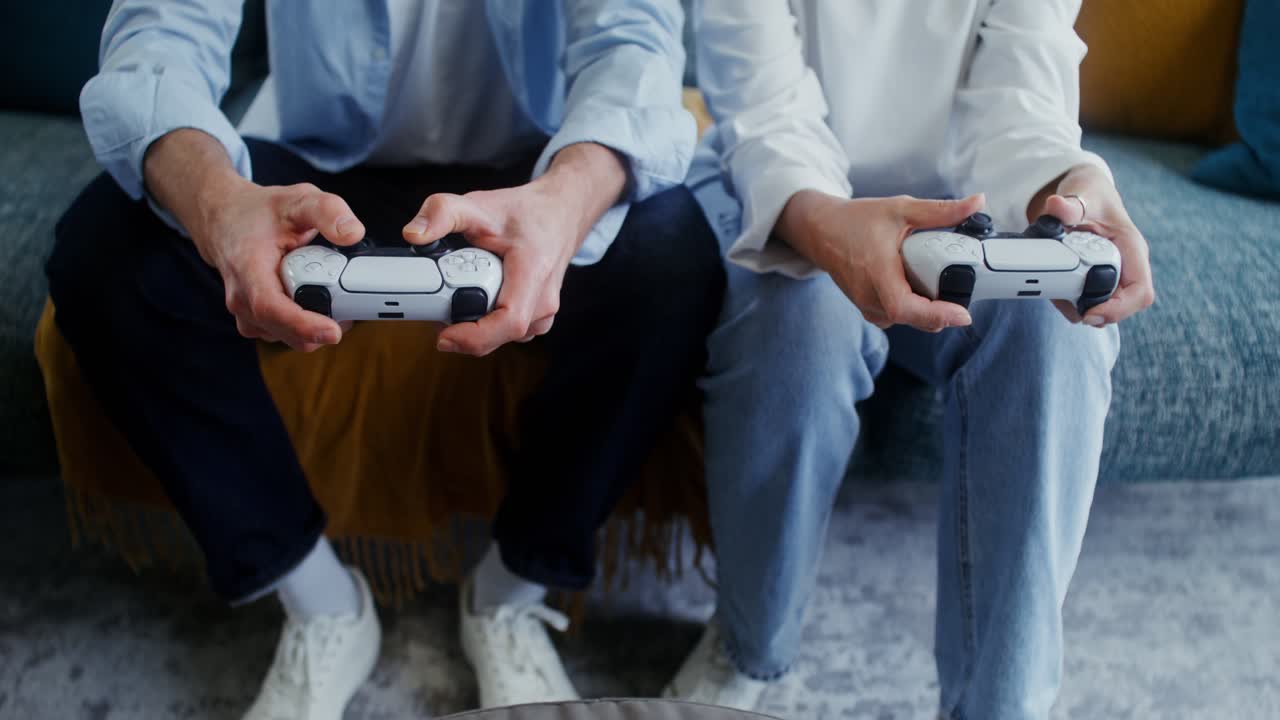 People Playing Video Games with PlayStation Controllers