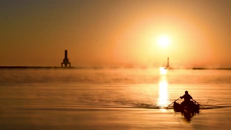 Ein-Einsamer-Mann-Rudert-Sein-Boot-Im-Goldenen-Sonnenlicht-Des-Sonnenaufgangs