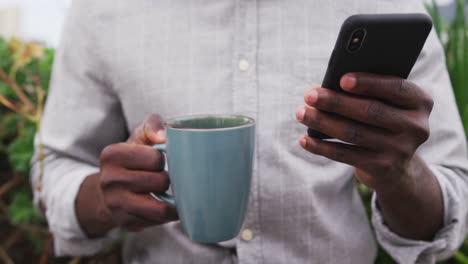 Close-up-view-of-woman-with-coffee-and-using-smartphone