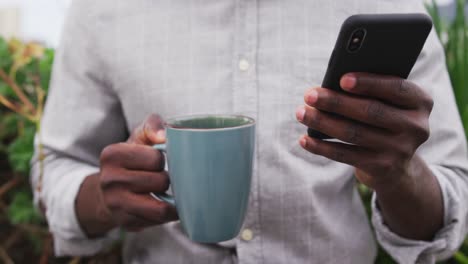 close up view of woman with coffee and using smartphone