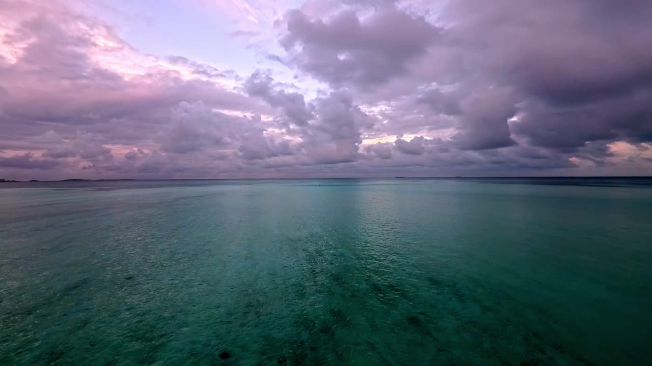 Landskab med vid engel af roligt turkis tropisk hav under en dramatisk skyet himmel