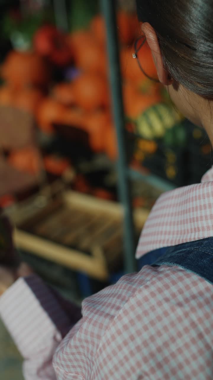 mujer examinando una calabaza en un parche de calabazas