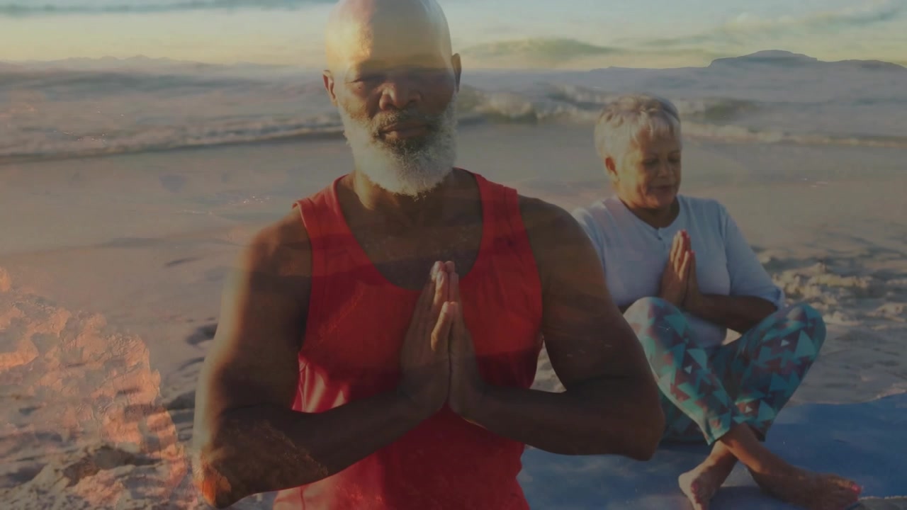 La telecamera si apre su un'inquadratura ampia, il leader preme i palmi delle mani, il partner lo imita, mentre la luce del sole guida una meditazione congiunta.