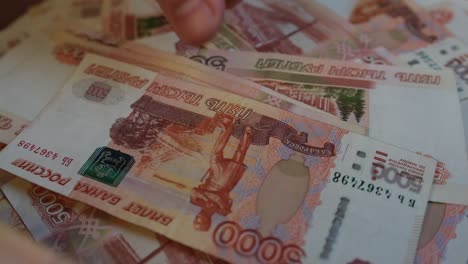 close-up of hands counting money leafing through each banknote