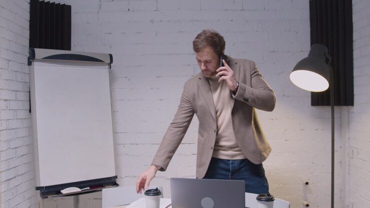 Uomo d'affari che parla al telefono cellulare in ufficio
