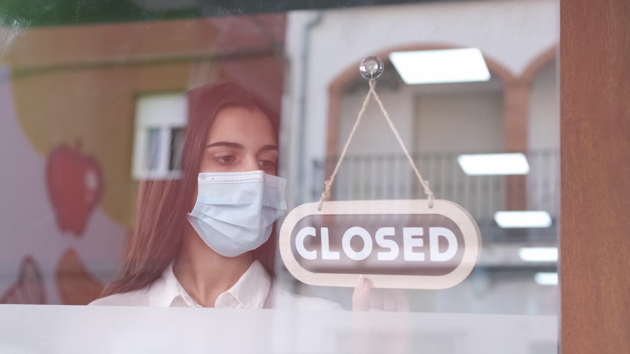 Young sad woman with face mask closing her business for corona virus pandemic. 4k 60fps