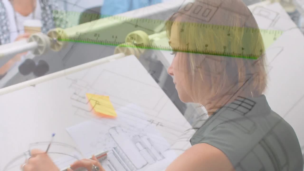 회전 계획 도면 위에서 스튜디오 몬태지에서 일하는 아키텍트