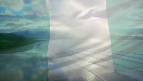 Animation-of-flag-of-nigeria-waving-over-beach-landscape,-cloudy-blue-sky-and-sea