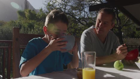 Family-eating-breakfast-together-outdoors