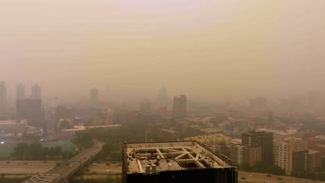 Drone-shot-rising-over-a-apartment,-revealing-Harlem,-low-visibiliy-caused-by-Canadian-fires-in-New-York,-USA