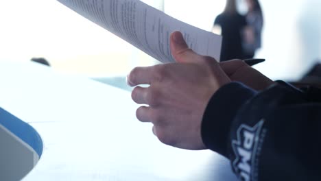 person signing documents at a meeting