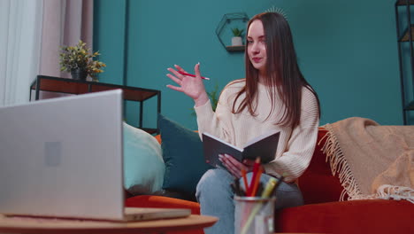 Young-woman-teacher-freelancer-consult-student-by-laptop-use-modern-tech-for-elearning-at-home-room