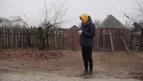 man using phone in rural autumn setting