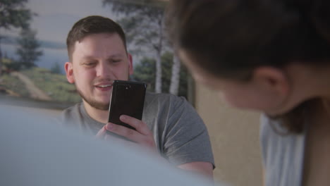 hombre y mujer usando teléfono inteligente