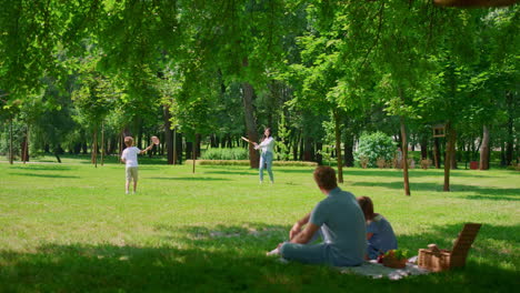 father watching badminton game with gaughter on picnic. active family rest.