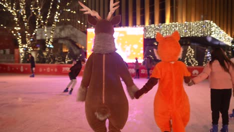niños patinando sobre hielo con disfraces de animales por la noche