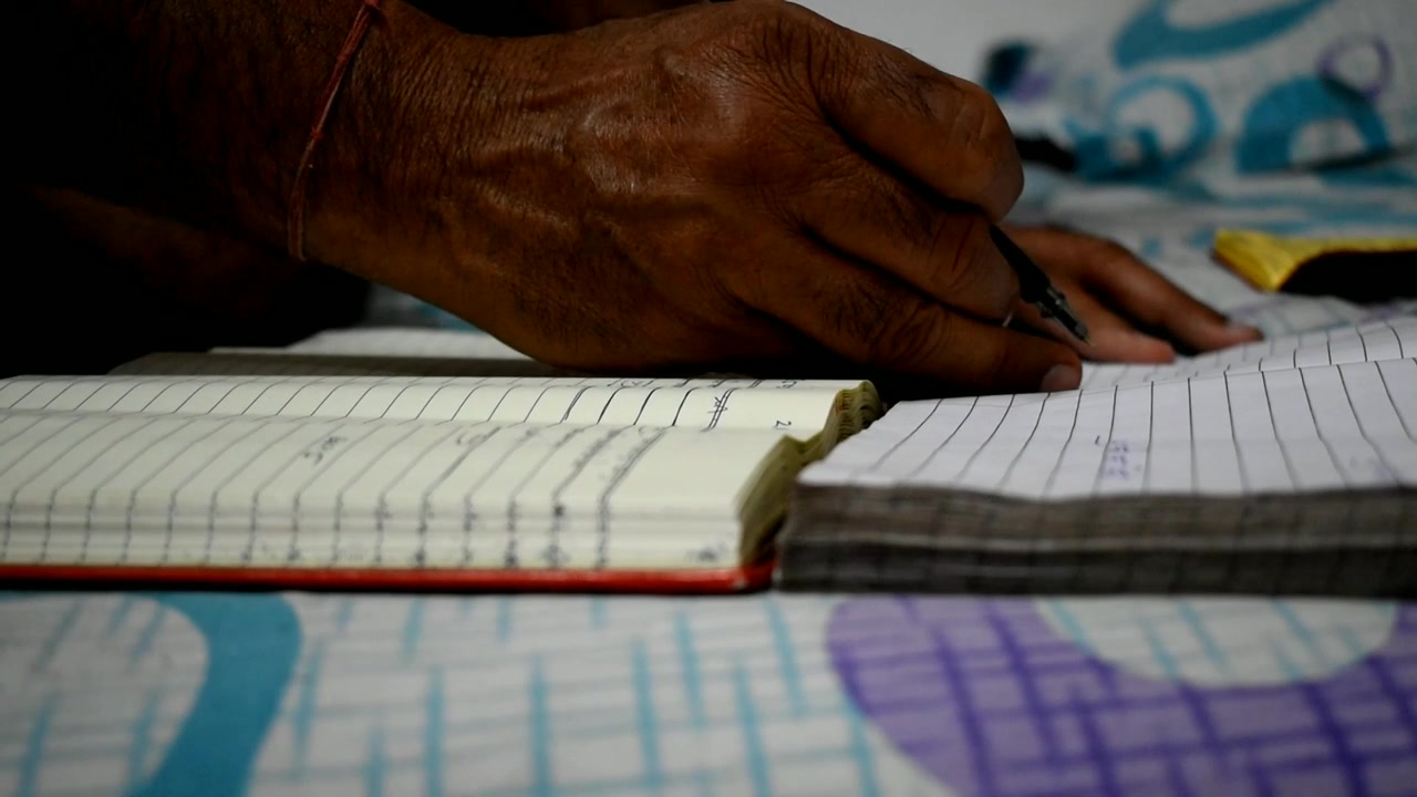 a man maintaining written accounting of his local business