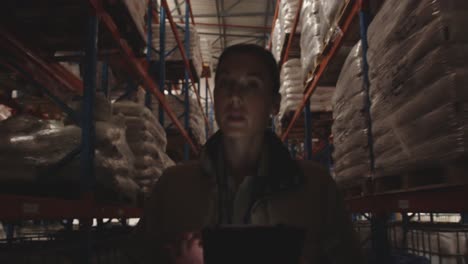 female warehouse worker patrolling warehouse corridor at night 4k