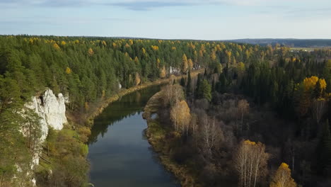 autumnal river landscape with cliffs and forest