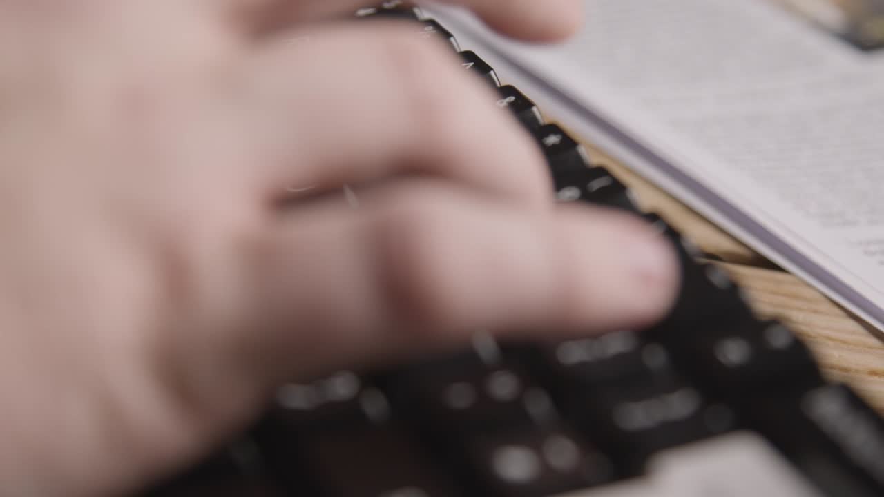 persona que usa el teclado junto al titular del periódico que discute las condiciones climáticas extremas y la huelga industrial