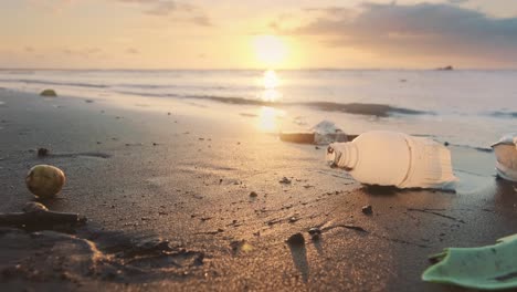 fragments plastic bottles lying on sand sea beach are washed by waters of surf