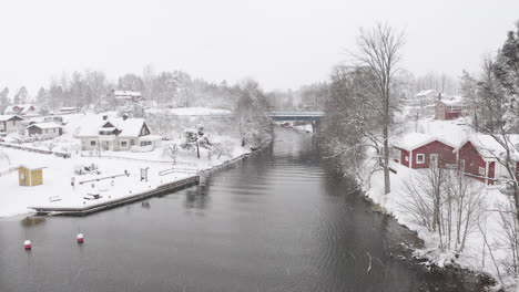 aerial shot of a small village with a small bridge by a lake in sweden