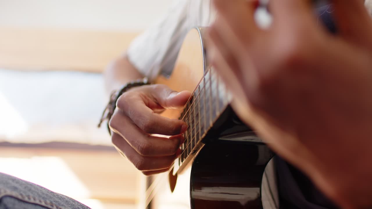 Vídeo de un guitarrista tocando y rasgueando las cuerdas con la mano derecha en su habitación para practicar