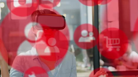 Multiple-red-digital-icons-floating-against-caucasian-businesswoman-wearing-vr-headset-at-office