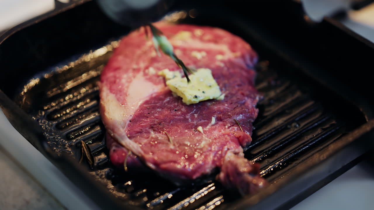 Close up of a juicy steak being moved with a spatula on a hot grill pan