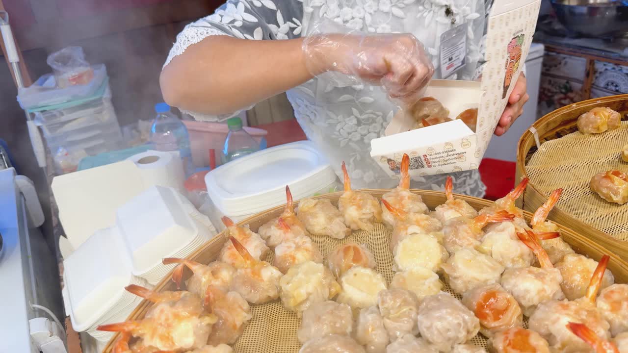 Woman serving dumplings at a food stall