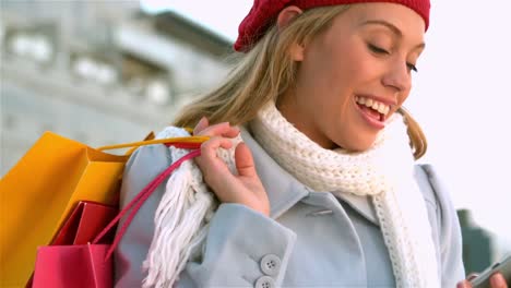 chica sonriendo bastante mientras usa un teléfono inteligente