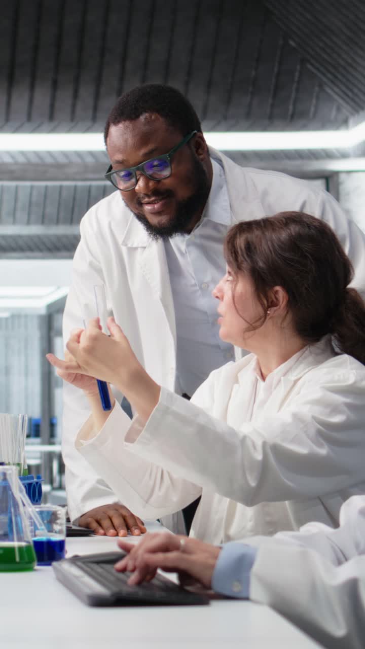 Vertical video Multiethnic chemical engineers using laboratory glassware with solution