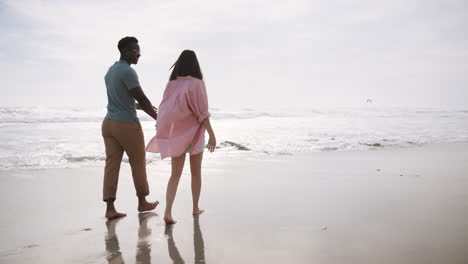 couple walking on the beach holding hands