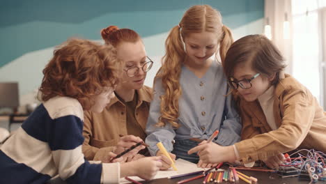 teacher and pupils drawing robot scheme on paper sheet
