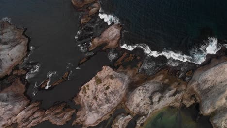 aérea de cima para baixo sobre penhascos altos com ondas quebrando durante o tempo ruim