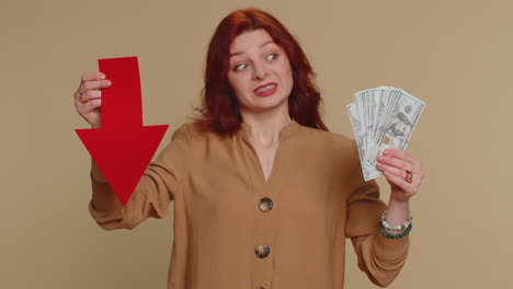 woman holding a red arrow down and cash