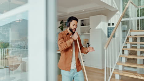 man singing into mop in his modern house