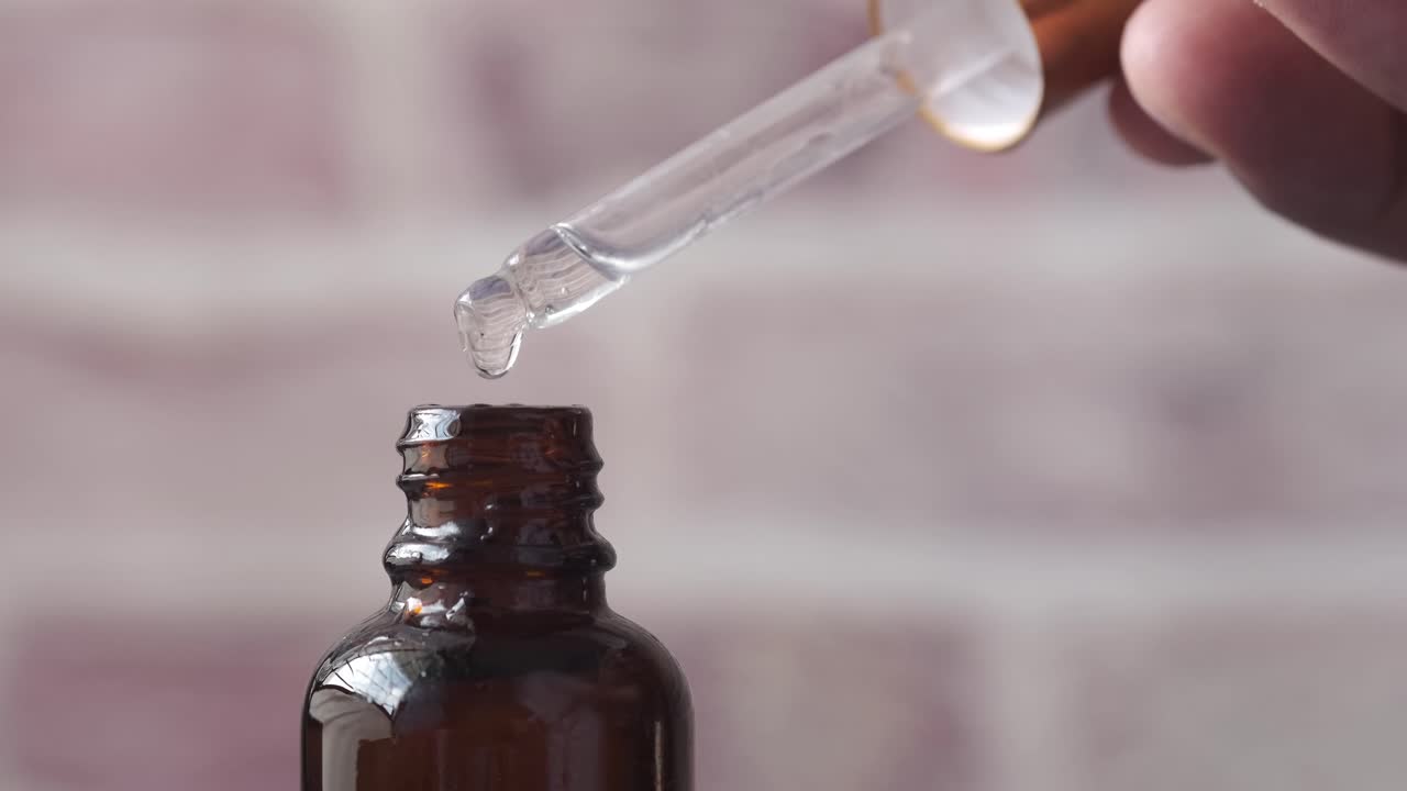 Dropper Filling a Brown Bottle with Liquid