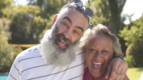 smiling senior friends enjoying outdoor time together, embracing and laughing