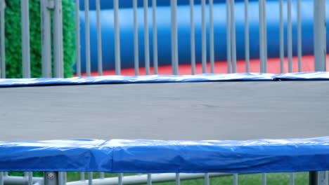 slow motion of a little girl jumping on a big trampoline in the park