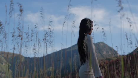 young beautiful woman walking in field enjoying scenic nature views