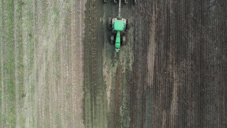 a tractor tills a wisconsin farm field after a manure spreader has spread liquid manure on the farm field