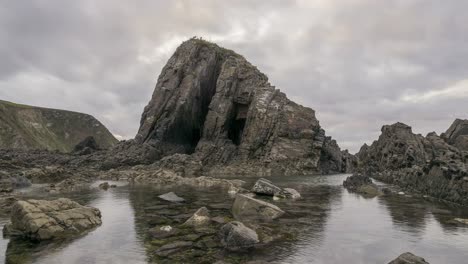 rocks and transparent seawater against cloudy sky