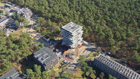 antena cinematográfica de un hermoso edificio de apartamentos de nueva construcción con un techo lleno de paneles solares fotovoltaicos