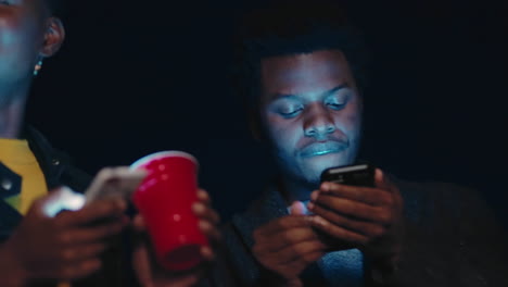 Couple-of-friends-at-night-party-with-phone